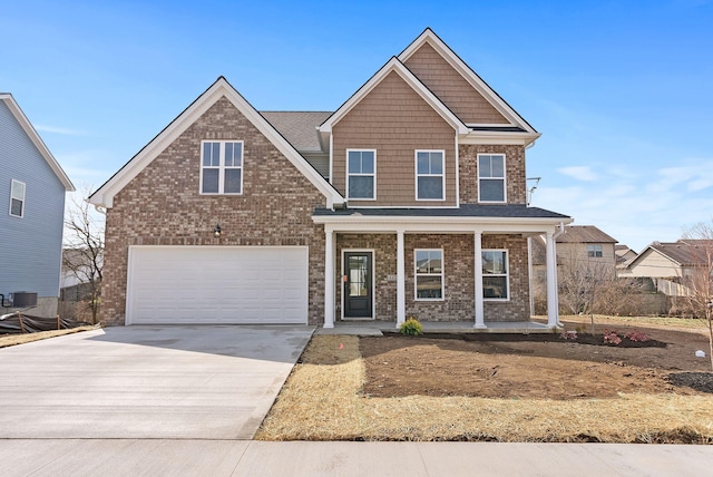 view of front of property with brick siding, a porch, concrete driveway, central AC, and an attached garage