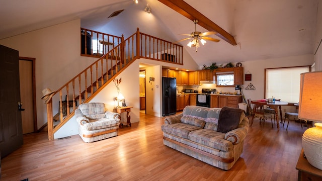 living room featuring light hardwood / wood-style flooring, beam ceiling, high vaulted ceiling, and ceiling fan