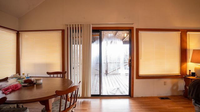 doorway to outside featuring light hardwood / wood-style floors and vaulted ceiling