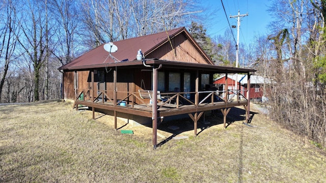 rear view of house featuring a deck and a yard