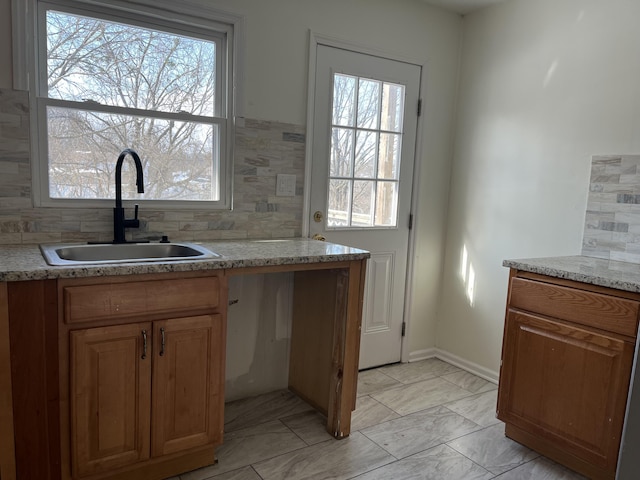 kitchen featuring sink, backsplash, and a healthy amount of sunlight