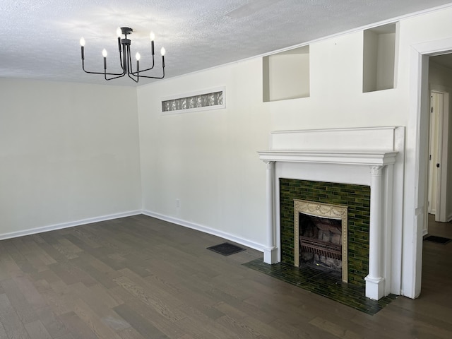 unfurnished dining area featuring dark wood-type flooring, a textured ceiling, and an inviting chandelier