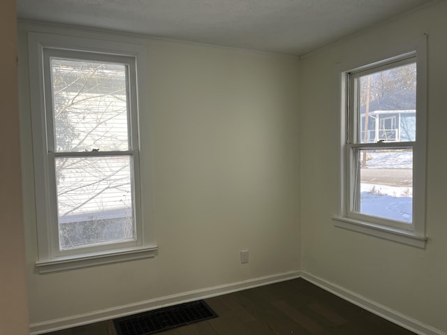 empty room with dark wood-type flooring and ornamental molding