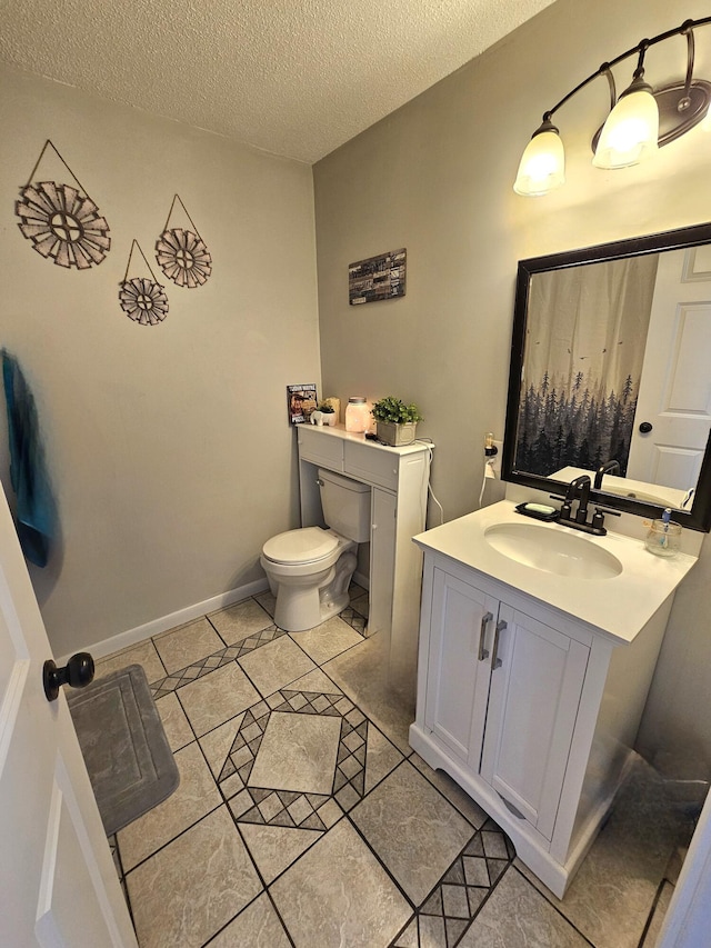 bathroom with vanity, tile patterned floors, a textured ceiling, and toilet