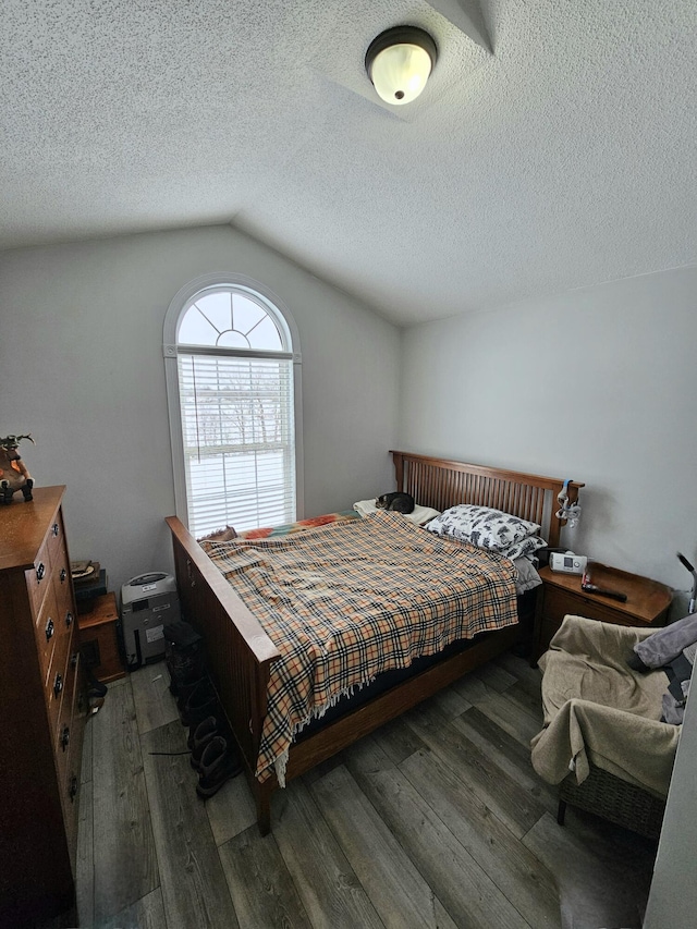 bedroom featuring hardwood / wood-style flooring, vaulted ceiling, and a textured ceiling