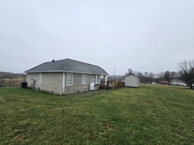 rear view of house with a yard and a shed