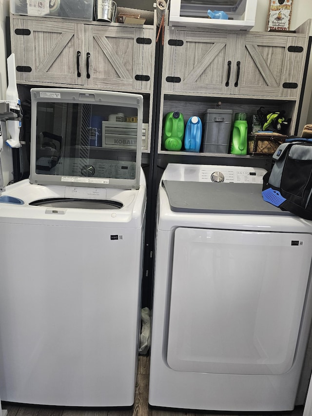 laundry area featuring separate washer and dryer and cabinets