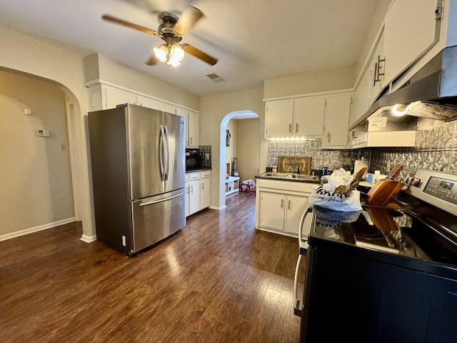 kitchen featuring dark wood-type flooring, white cabinetry, ceiling fan, stainless steel appliances, and backsplash