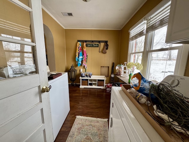 laundry room featuring separate washer and dryer, dark hardwood / wood-style flooring, and cabinets