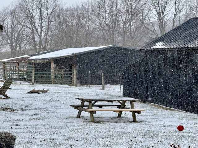 snowy yard with an outbuilding