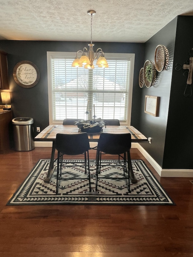 dining space with hardwood / wood-style floors, a textured ceiling, and a chandelier