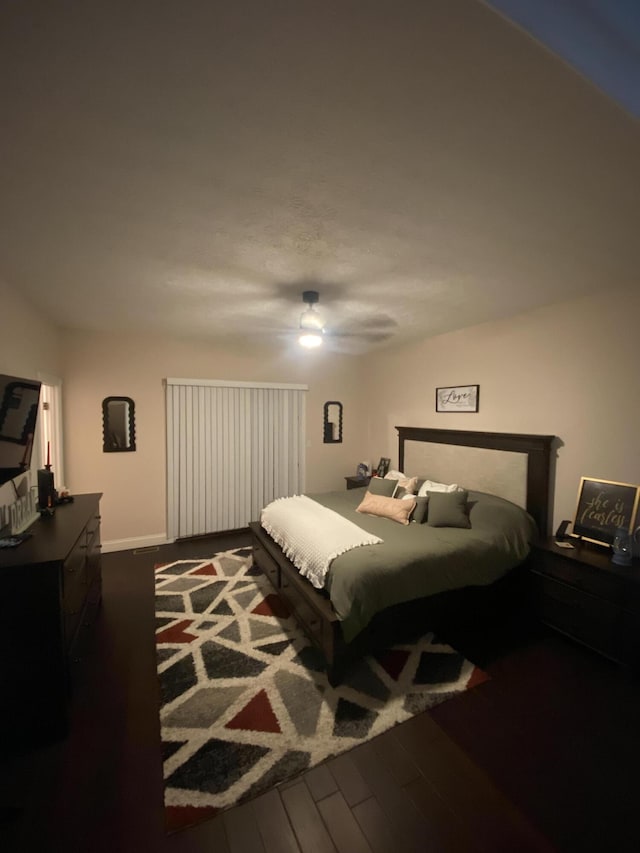 bedroom with dark hardwood / wood-style flooring and ceiling fan