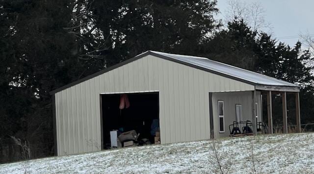 snow covered structure with a garage