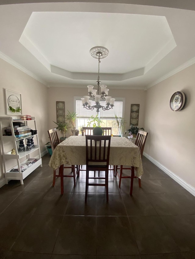 dining room with a raised ceiling, crown molding, and a notable chandelier