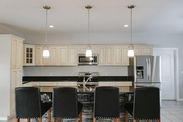 kitchen featuring cream cabinets, a center island, hanging light fixtures, and appliances with stainless steel finishes