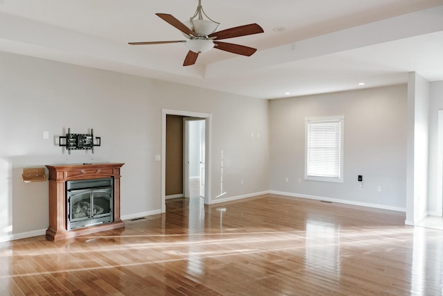 unfurnished living room featuring ceiling fan and hardwood / wood-style floors