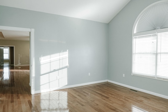 empty room featuring hardwood / wood-style floors and lofted ceiling