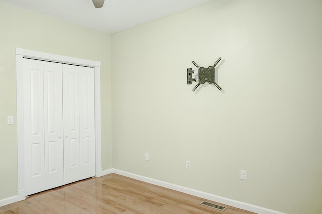 unfurnished bedroom featuring wood-type flooring, a closet, and ceiling fan