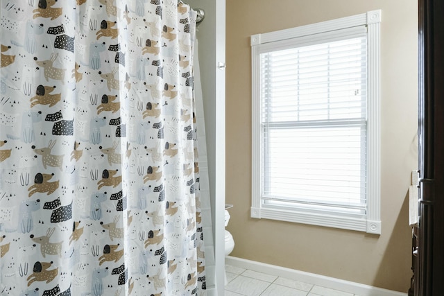 bathroom featuring tile patterned floors, walk in shower, and toilet