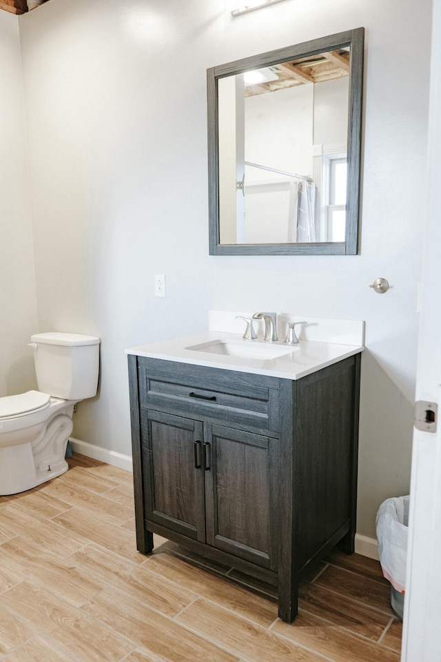 bathroom with toilet, walk in shower, and vanity