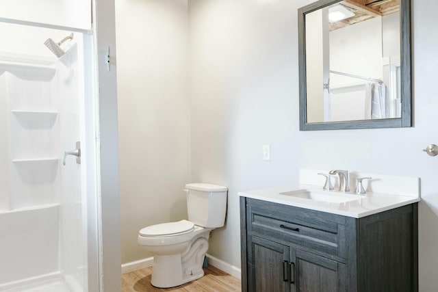 bathroom with wood-type flooring, toilet, walk in shower, and vanity