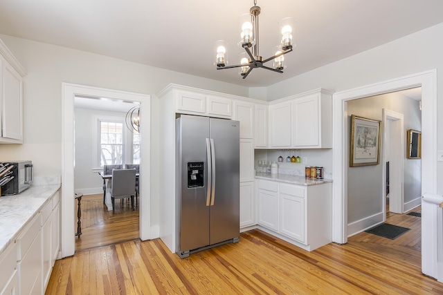 kitchen featuring stainless steel fridge, light hardwood / wood-style floors, and white cabinets