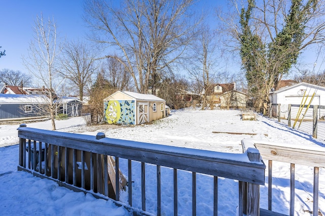 yard covered in snow with a storage shed