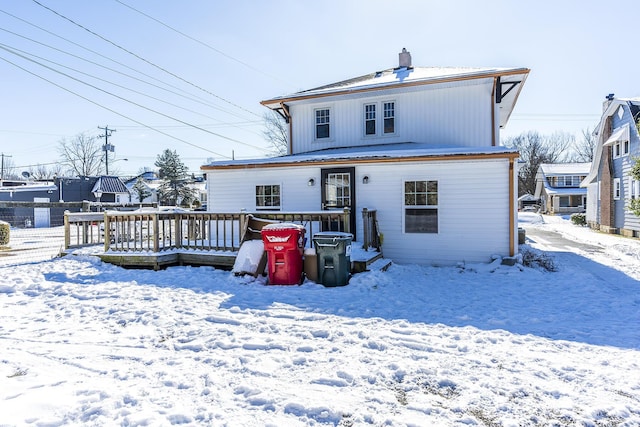 snow covered house with a deck