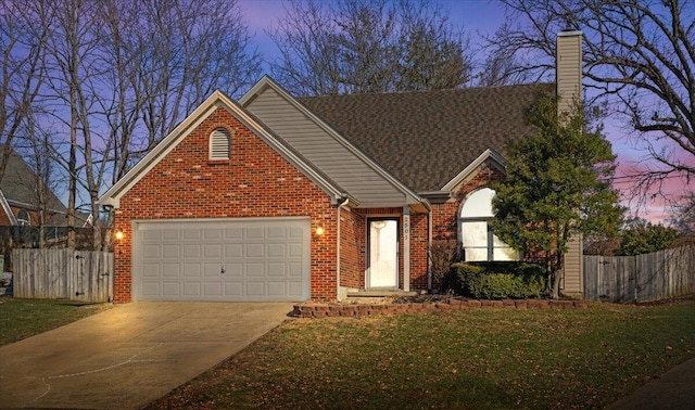 front of property with a garage and a lawn