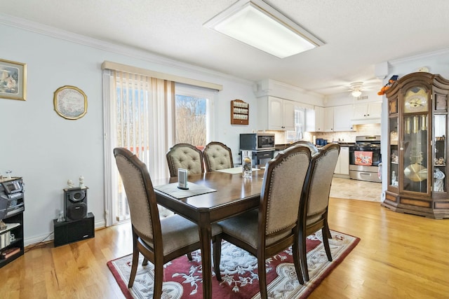 dining space with a textured ceiling, ceiling fan, ornamental molding, and light hardwood / wood-style flooring