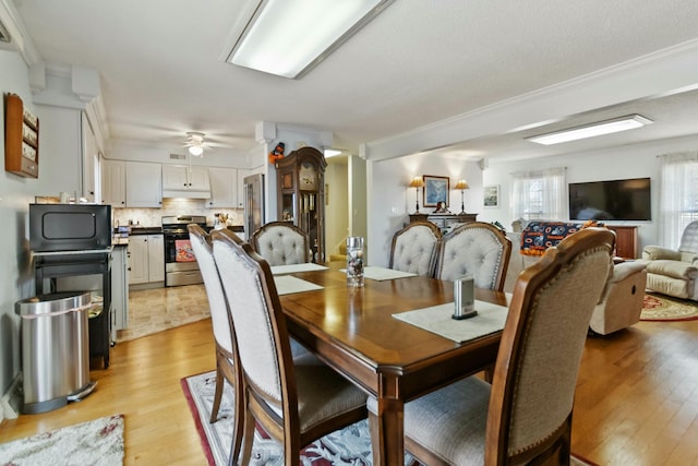 dining room featuring ceiling fan, light hardwood / wood-style flooring, and crown molding