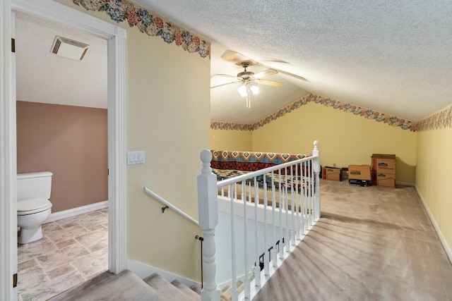 interior space featuring ceiling fan, vaulted ceiling, and a textured ceiling