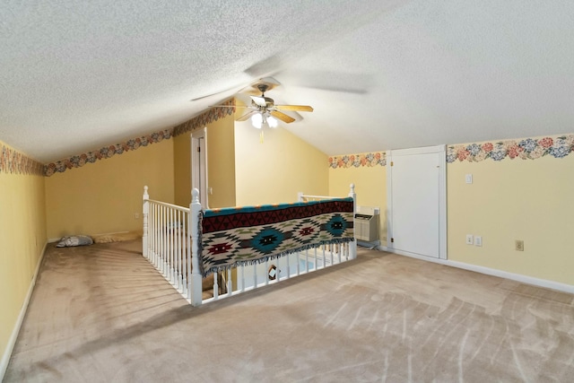 interior space featuring light carpet, ceiling fan, lofted ceiling, and a textured ceiling