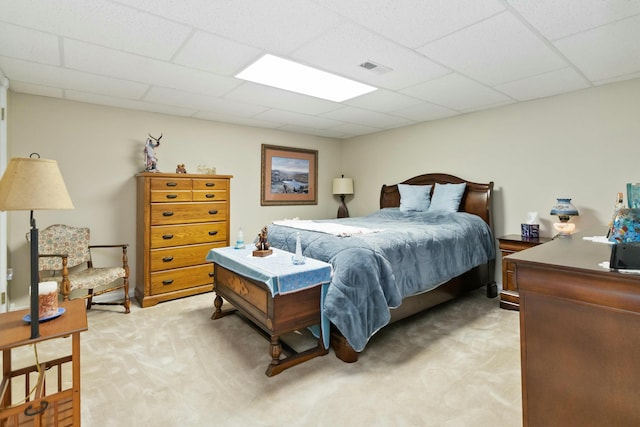 bedroom with light colored carpet and a drop ceiling