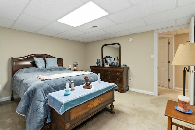 bedroom featuring light carpet and a paneled ceiling