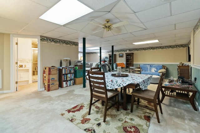 dining area featuring ceiling fan, a drop ceiling, and carpet