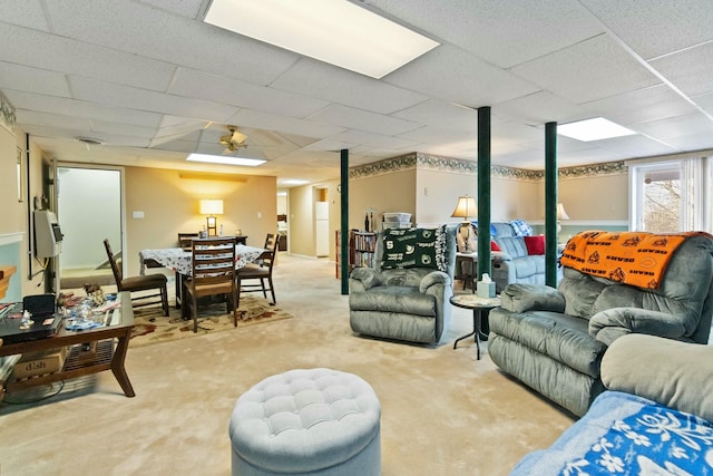 carpeted living room with a drop ceiling