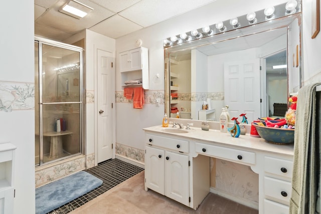 bathroom with walk in shower, vanity, a paneled ceiling, and tile patterned floors