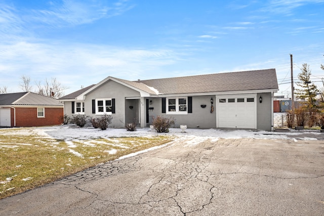 ranch-style home featuring a garage and a front lawn