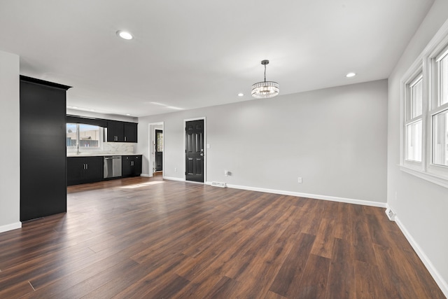 unfurnished living room featuring dark hardwood / wood-style flooring and a chandelier