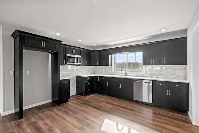 kitchen with dark hardwood / wood-style flooring, sink, tasteful backsplash, and appliances with stainless steel finishes