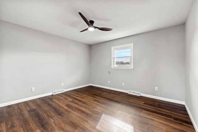 spare room with dark wood-type flooring and ceiling fan