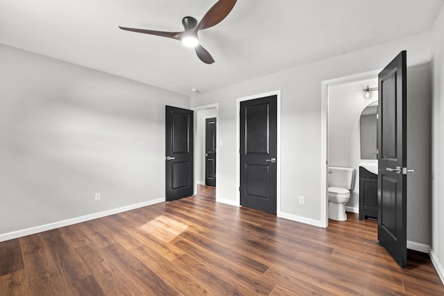 unfurnished bedroom featuring ensuite bathroom, dark hardwood / wood-style floors, and ceiling fan