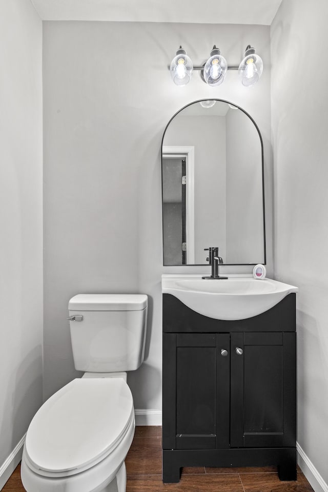 bathroom featuring vanity, hardwood / wood-style floors, and toilet