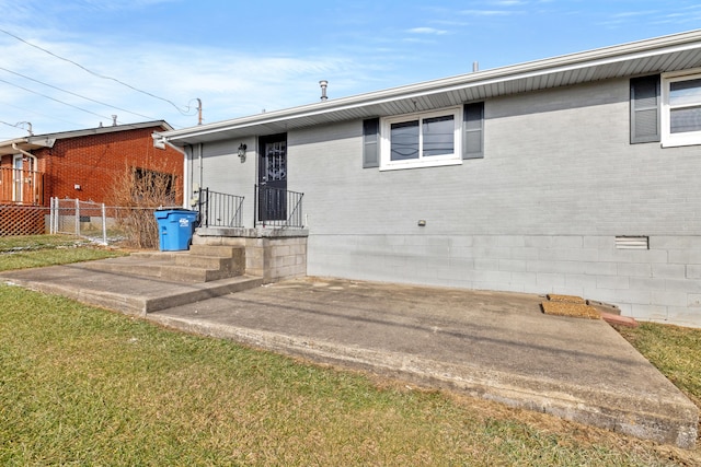 back of house featuring a lawn and a patio area