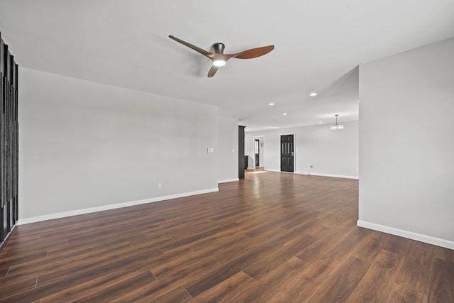 unfurnished room with dark hardwood / wood-style floors and ceiling fan with notable chandelier