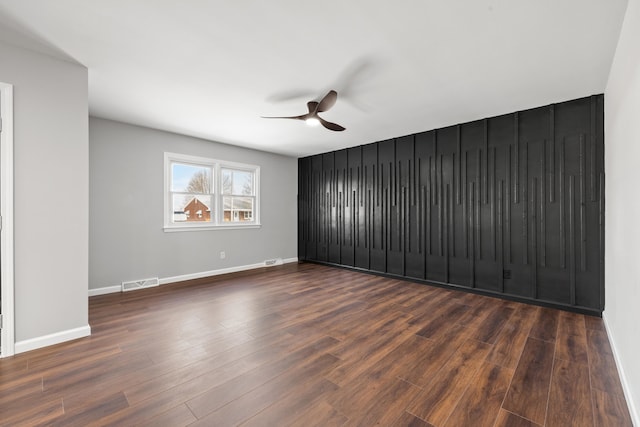 unfurnished room with dark wood-type flooring and ceiling fan