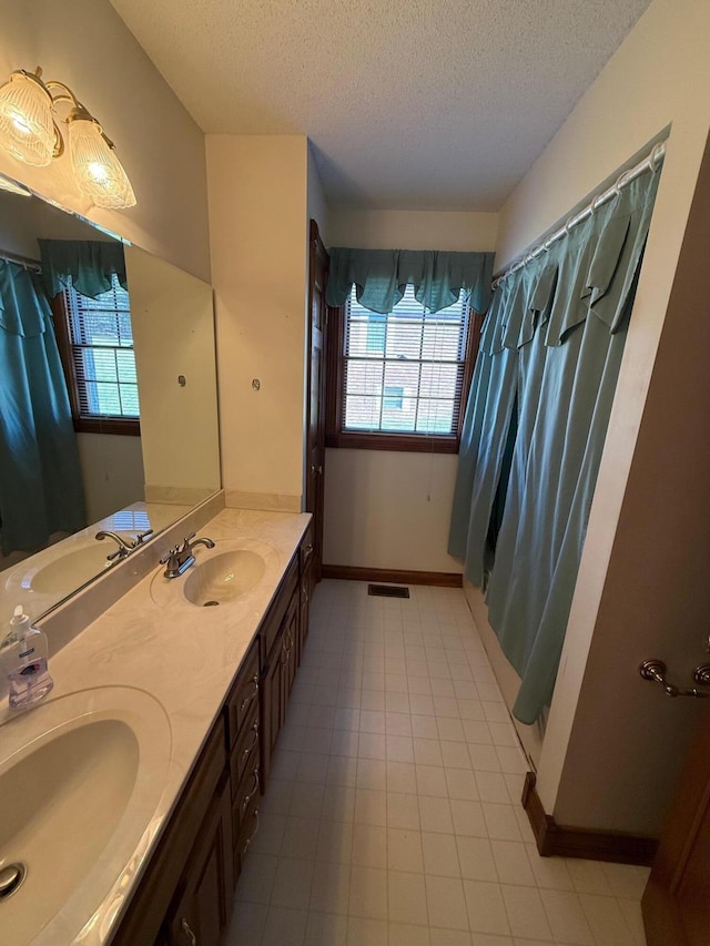 bathroom with a shower with curtain, a textured ceiling, and vanity