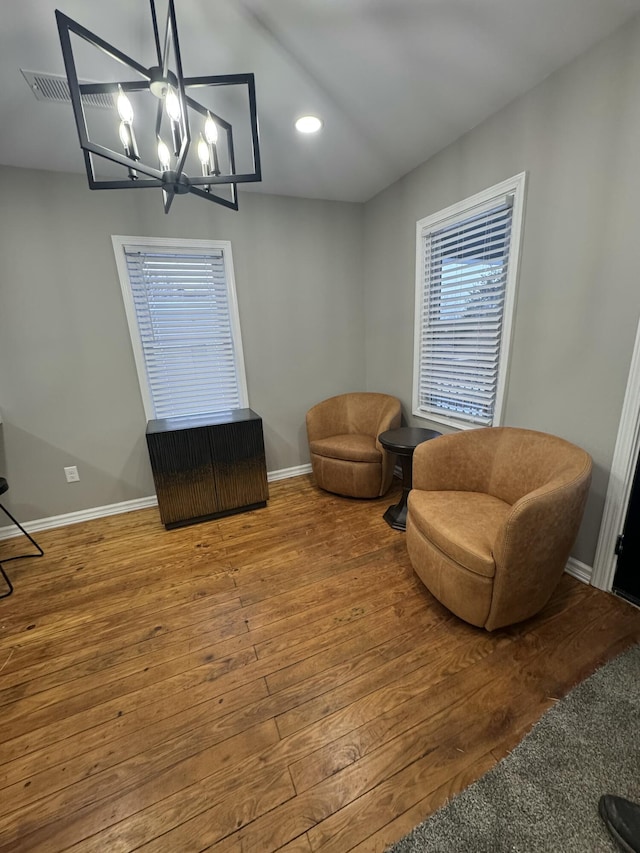 sitting room with hardwood / wood-style flooring and a chandelier