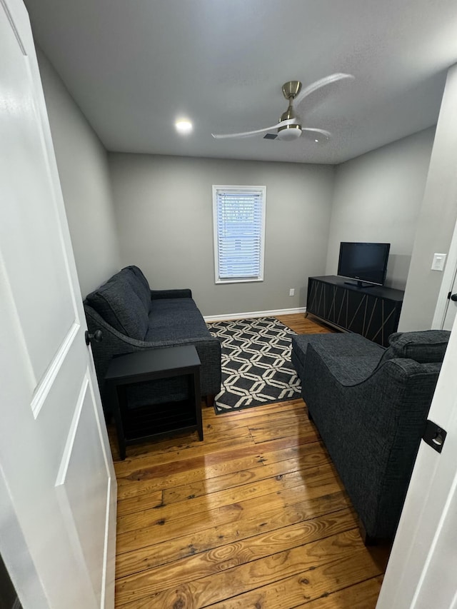 living room featuring hardwood / wood-style floors and ceiling fan